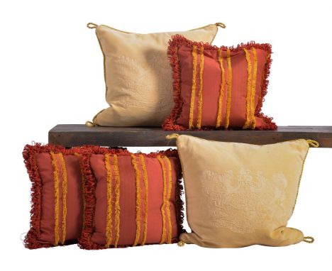 A GROUP OF FIVE CREAM AND RED CUSHIONS OF RECENT MANUFACTURE  with gold fringe and piping, the cream pair with crests the red