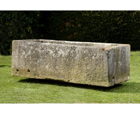 A large carved limestone trough  69cm.; 27ins high by 213cm.; 84ins long by 92cm.; 36ins deep