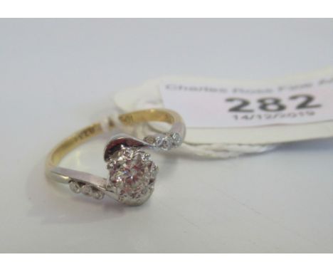 A single stone diamond ring, the brilliant cut diamond in engraved setting with six stone diamond crossover mount marked 18 c