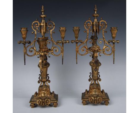 A set of two elaborate golden candlestick holders, each with four ornate arms. Stunning details on the lions' faces and acant