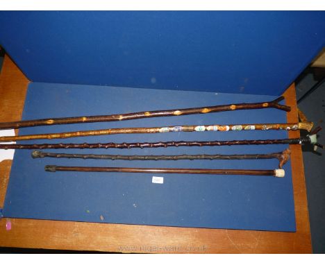 A quantity of walking Sticks including an antler handled walking stick with badges, thumbsticks, etc.