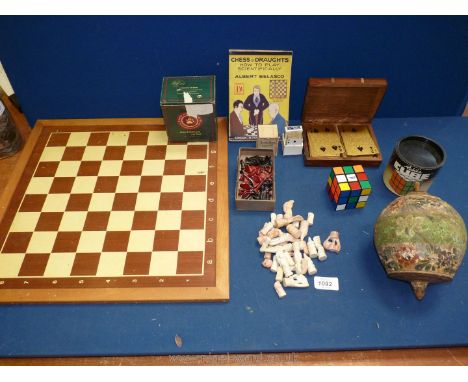A small box of games including two boxes of chess pieces, a miniature pack of playing cards, Rubik cube, chess board and vint