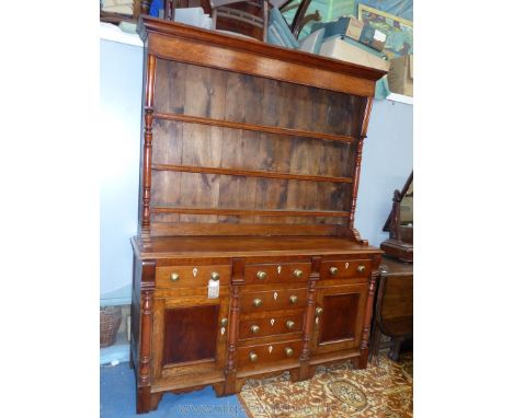 A mellow oak North Wales type Dresser, the base with a central flight of four drawers with lute shapes lock escutcheons and f