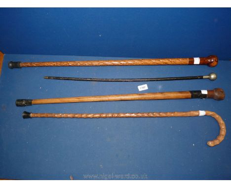 Four walking sticks including one knobbly, one twisted Tigerwood and a swagger stick with coat of arms to knob end.