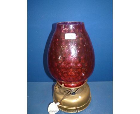 A large church oil heater/lamp on brass base, glass cranberry shade with strawberry pattern, has some damage to shade, 17" ta