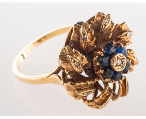 A 9ct yellow gold cocktail ring, of floral and foliate design and set with circular-cut sapphires and interspaced with small 