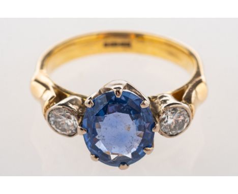 A three stone sapphire and diamond ring, claw set to the centre with an oval-cut sapphire, sapphire approx. 1.40 carats, and 