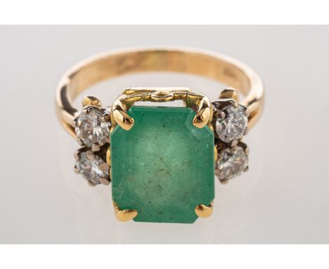 An emerald and diamond ring, claw set to the centre with a rectangular-cut emerald, emerald approx. 4.80 carats, with two bri
