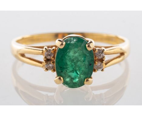 An emerald and diamond ring, set with an oval-cut emerald with two small brilliant-cut diamonds set to each side, marked 585,