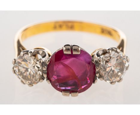 A ruby and diamond three stone ring, set centrally with a circular-cut ruby, approx. 1.25 carats, with a brilliant-cut diamon