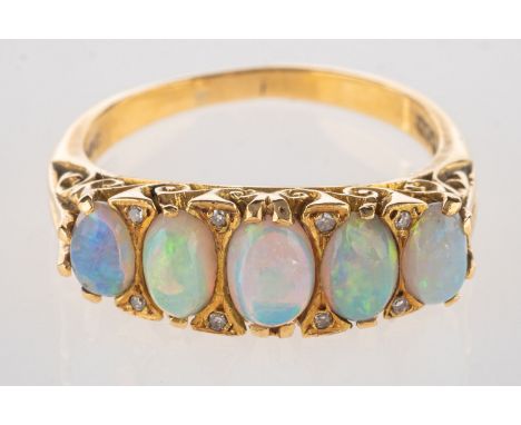 An 18ct gold opal and diamond scroll ring, set with five opal cabochons, each interspaced by two single-cut diamonds, (eight 