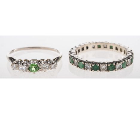A group of two rings, including a five stone ring set to the centre with a circular-cut green stone (possibly green garnet?),