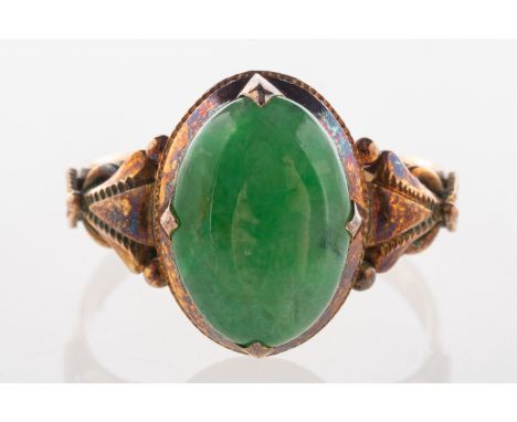 A jade ring, an oval-cut jade cabochon in an ornately carved shoulder ring, marked 14k, size K to K1/2, 2.5grams.