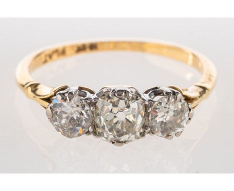 A three stone diamond ring, set with an old mine-cut diamond and two old-cut diamonds, diamonds approx. 0.80 carat total, mar