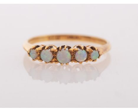 A five stone opal ring, claw set with five graduated circular-cut opal cabochons, marked 18c, size K1/2, 2.1grams.
