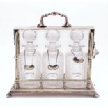 An early 20th century three bottle silver plated tantalus by Mappin & Webb,