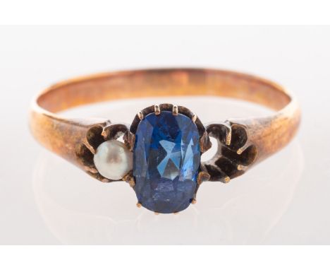 An antique three stone ring, set to the centre with an oval mixed-cut sapphire and set each side with a pearl, (one missing),