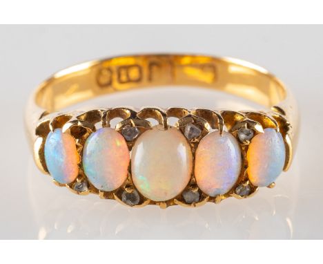 An antique 18ct gold opal set ring, with five oval-cut opal cabochons and seven small rose-cut diamonds (one missing), indist