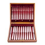 A cased set of twelve mother of pearl and silver plated dessert knives and forks, with silver bands,