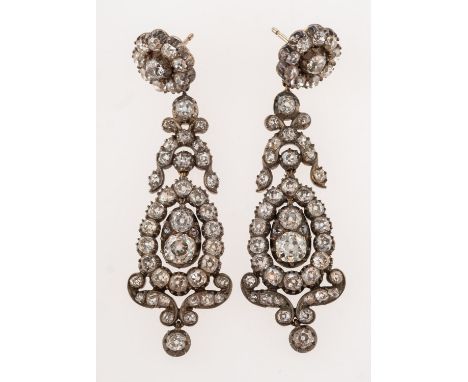 A pair of antique diamond drop earrings, each set to the top with a flowerhead with ornate suspending openwork chandelier dro