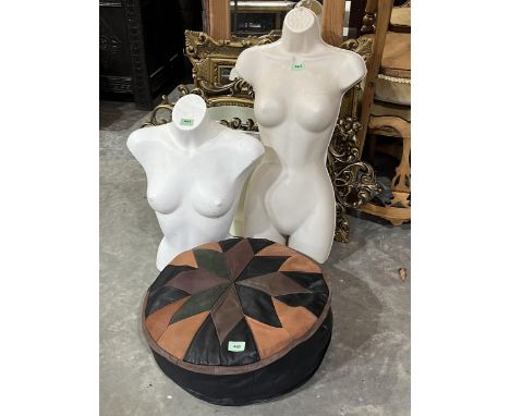 A leather pouffe and two mannequins.