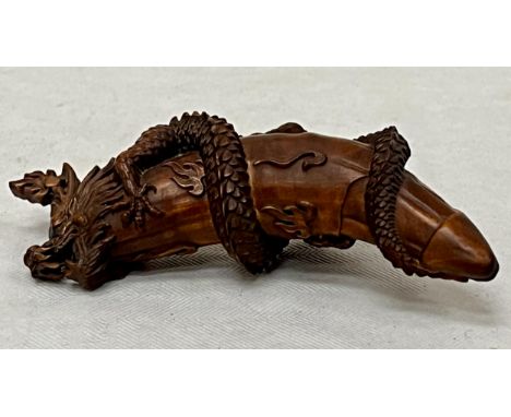 A Chinese boxwood netsuke, crisply carved with a dragon. 3¼" long.
