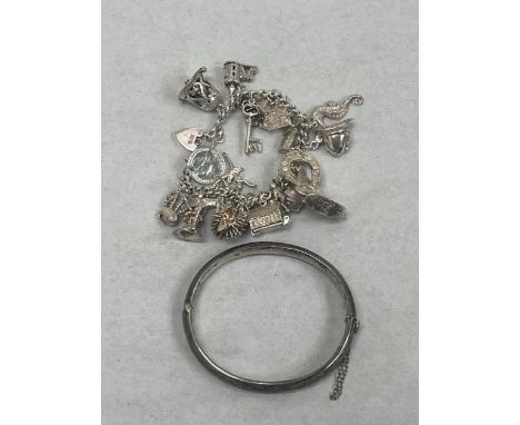 A silver charm bracelet and a silver hinged bangle. 2 ozs 10 dwts.
