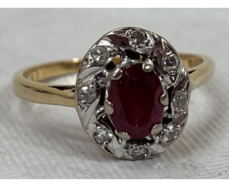 A ruby and diamond cluster ring. In gold marked 18. 3g gross. Size O.