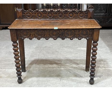 A Victorian carved oak side table with end drawer on bobbin turned legs. 41" wide.
