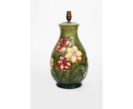 'Fresia' a large Moorcroft Pottery lamp base, painted in pink, yellow and blue on a green ground, impressed factory marks, pa
