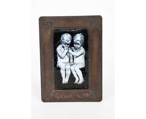 A Limoges enamel panel of two young boys, painted en grisaille, one biting into an apple, set in a metal frame probably desig