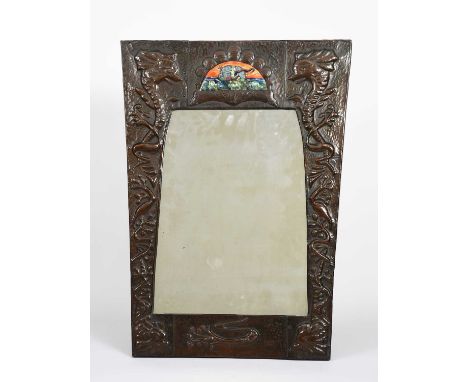 An Arts and Crafts patinated copper wall mirror with enamelled panel, flaring rectangular form, hammered in low relief with s