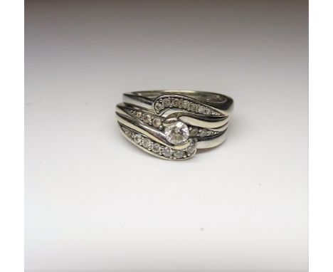 A set of three 9ct white gold and diamond rings, the principal ring mounted with a circular cut diamond, between diamond thre
