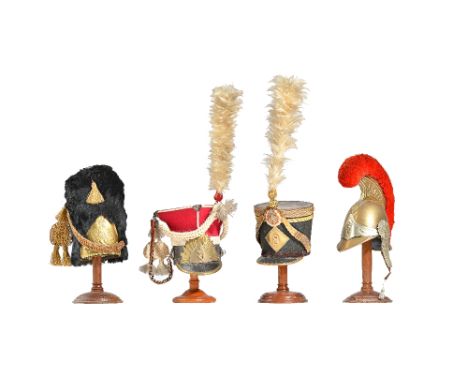 Four miniature model military helmets/hats comprising; French Cuirassier brass helmet with red plume, a Grenadier Guards offi