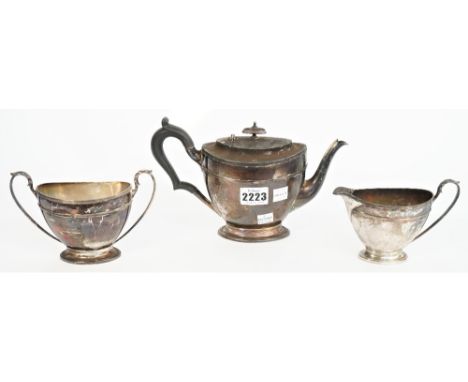 Silver tea wares, comprising; a teapot with black fittings, Sheffield 1910, a twin handled sugar bowl, Sheffield 1911 and a m