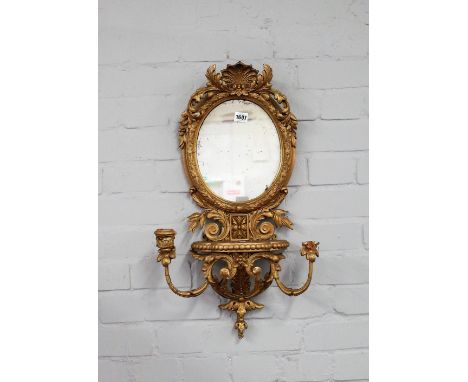 An early 20th century gilt framed girandole wall mirror, with oval plate above shelf and twin candle holder, 37cm wide x 65cm