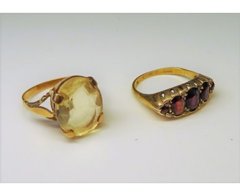 A 9ct gold and garnet five stone ring, Birmingham 1972, ring size Q and a gold ring, claw set with an oval cut citrine, ring 