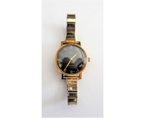 An Omega gilt metal fronted and steel backed lady's wristwatch, the signed black dial with gilt Roman numerals and with gilt 