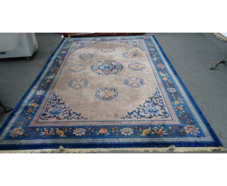A Chinese carpet, the mushroom coloured field with a larger central leaf roundel, surrounded by eight smaller circles; scroll