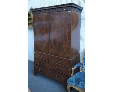 A George III mahogany linen press, the pair of oval panel doors, over two short and two long drawers, on bracket feet, 129cm 