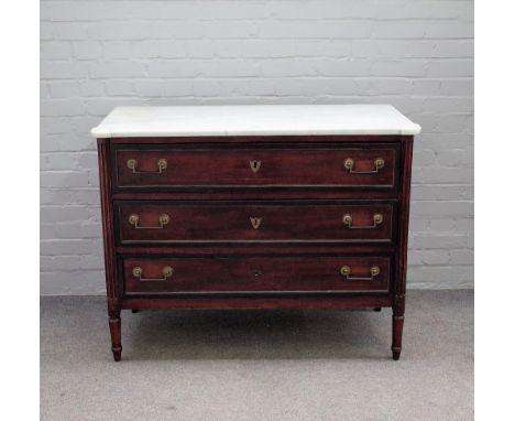 A late 19th century French commode of Louis XVI design, the marble top over a mahogany base with three long drawers, on turne