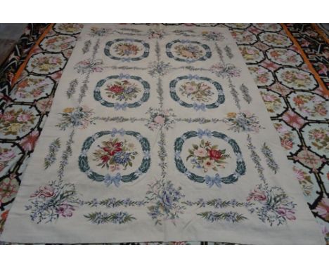 A modern tapestry needlework, the fawn field with six panels, each with laurel leaves and floral bouquets, 284cm x 168cm. 
