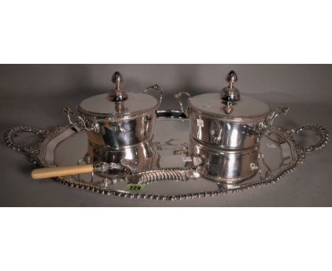 Silver plated wares, including; an oval twin handled serving tray, two lidded entree dishes and a crumb scoop, (4).  