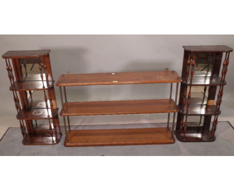 A pair of faux rosewood mirror back hanging four tier shelves, 32cm wide x 75cm high, together with another three tier shelf,