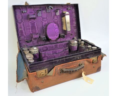 A silver mounted travelling part toilet set, fitted with a variety of bottles, jars, brushes and further accessories, (severa