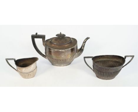 A late Victorian silver three piece tea set, comprising; a teapot with black fittings, a twin handled sugar bowl and a milk j