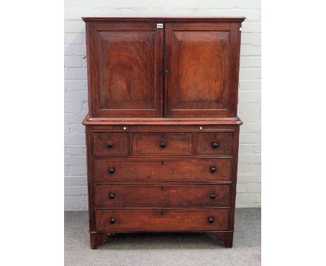 A 19th century Anglo-Indian cabinet on chest, the pair of panel doors enclosing shelves and pair of drawers, the base with br