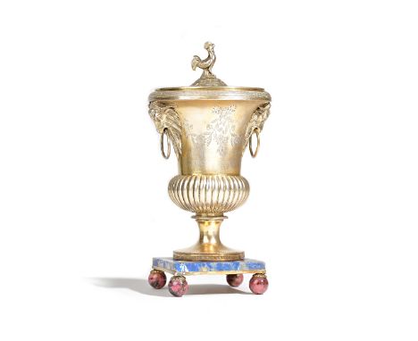 A French Empire silver gilt urn and cover, the body of bulbous form, with fluted decoration, the top with twin goat's mask an