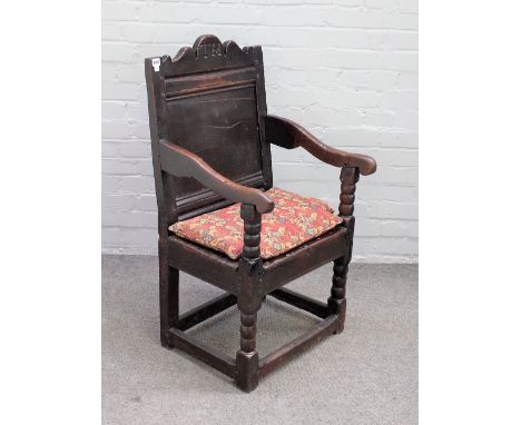 A 17th century oak Wainscot open armchair, with panel square back and solid seat, on turned supports, 54cm wide x 100cm high.