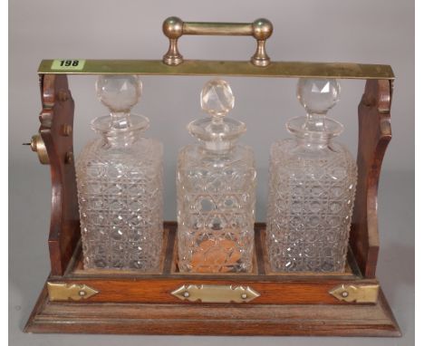 A mid-20th century oak and silver plated mounted tantalus with three 20th century cut glass decanters, 39cm wide x 32cm high.